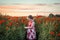 Pretty child young cute girl red dress stood peaceful tranquil poppy flower field landscape view poppies dusk sunset golden hour