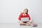 Pretty clever cross-legged teenager pointing upwards while sitting on the floor