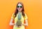 Pretty cool smiling girl in sunglasses with pineapple over colorful orange