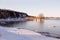 Pretty cove with chunks of ice floating in the river and a scattering of patrimonial houses at the foot of a cliff