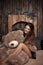 Pretty cute brunette girl posing with big teddy bear on the floor in cozy comfortable interior home.