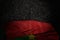 Pretty dark illustration of Burkina Faso flag with big folds on dark asphalt with free space for your text - any celebration flag