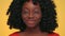 Pretty dark skinned woman winking and smiling at studio