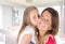 Pretty daughter girl kiss cute mother in home lifestyle concept