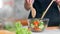 Pretty dieting female preparing organic vegetarian dish surrounded by cosiness cuisine interior