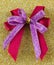 Pretty double gift bow on a sparkly surface.