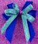 Pretty double gift bow on a sparkly surface.