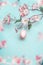 Pretty Easter background in pastel color. Spring blossom branches with pink hanging Easter egg at light blue. Easter greeting card