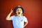 Pretty emothional children wear a hat on a red background