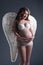 Pretty expectant woman posing with angel\'s wings