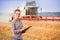 Pretty farmer girl with folder in wheat fild