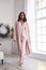 Pretty fashion beautiful woman sexy lady brunette curly hair dark tanned skin wear trend clothes knitted pink pink suit jacket top