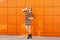 Pretty fashion woman in dress and sunglasses.Background of a bright orange wall.