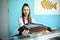 Pretty female fishmonger behind the counter holding a huge fish in her outstretched hands. Seafood retail at fish store