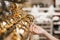 Pretty female hand reaching and grabbing Christmas decoration, shopping woman hand with nude nails touching luxury gold