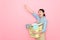 Pretty female housekeeper holding clothing basket