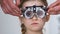 Pretty female kid in optical trial frame, optometrist choosing proper lens