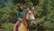 Pretty female sitting in saddle on purebred horse