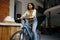 Pretty female student poses on bicycle in cafe