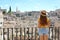 Pretty female tourist enjoys cityscape of Matera, Italy