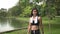 Pretty female wearing sportswear walking exercise pass swamp in park