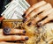 Pretty fingers of african american woman holding money close up with purse, luxury jewellery on python clutch
