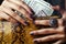 Pretty fingers of african american woman holding money closeup with purse, luxury jewellery on python clutch, cash for