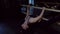 Pretty flexible girl with ponytail in black top bends body backward with leg on ballet handrail closeup slow motion