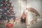 Pretty flexible young woman is doing sports near christmas tree, sports and holiday concept