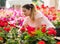 Pretty florists woman working with blooming flowers at a greenhouse