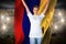 Pretty football fan in white cheering holding colombia flag