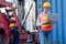 Pretty foreman woman stand with holding laptop for working in front of her co-worker fix the problem of vehicle in background of