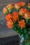 Pretty fresh orange roses on a wooden background.