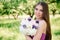 Pretty gentle young girl in a purple dress in garden with a bouquet in her hands looking at the camera. Professional