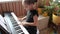 Pretty girl blogger playing classic digital piano during family home concert, smile at the end