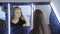 Pretty girl brushes her hair by hand sitting in front of mirror.