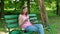 Pretty girl buy online sitting on the bench in the park. Happy women shopping via internet use smartphone at the open