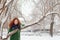 Pretty girl clings to tree outdoor at winter day