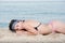 Pretty girl with great body lying on rocky sand