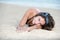 Pretty girl with great body lying on the sand