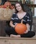 Pretty girl holding a large orange pumpkin