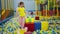 Pretty girl kid walking by colorful cubes at playground park and smiling