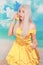 Pretty girl in pinup yellow dress on blue background. banana dieting.