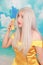 Pretty girl in pinup yellow dress on blue background. banana dieting.