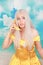 Pretty girl in pinup yellow dress on blue background. banana dieting.