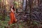 Pretty girl in plaid stands near downed trees in forest