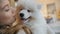 Pretty girl playing with samoyed puppy dog indoors