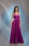 Pretty girl posing in plum violet evening dress