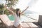 pretty girl raise her hands enjoying sunlight on tropical beach