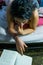 A pretty girl is reading a book on her bed. Close up view.